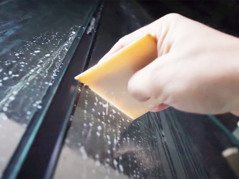 Der PALÜ Abstreichspachtel 568 in der Anwendung beim Versiegeln von Fenstern.