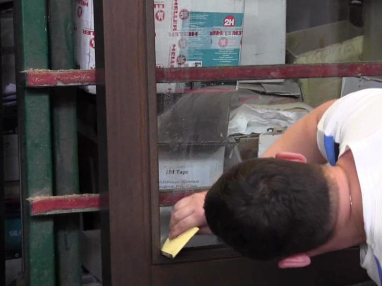 Der PALÜ Abstreichspachtel 568 in der Anwendung beim Versiegeln von Fenstern.